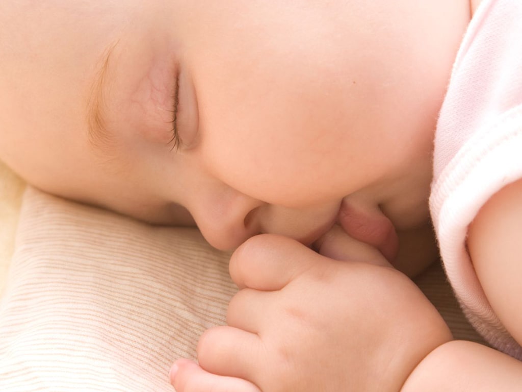 Baby sucking thumb while sleeping