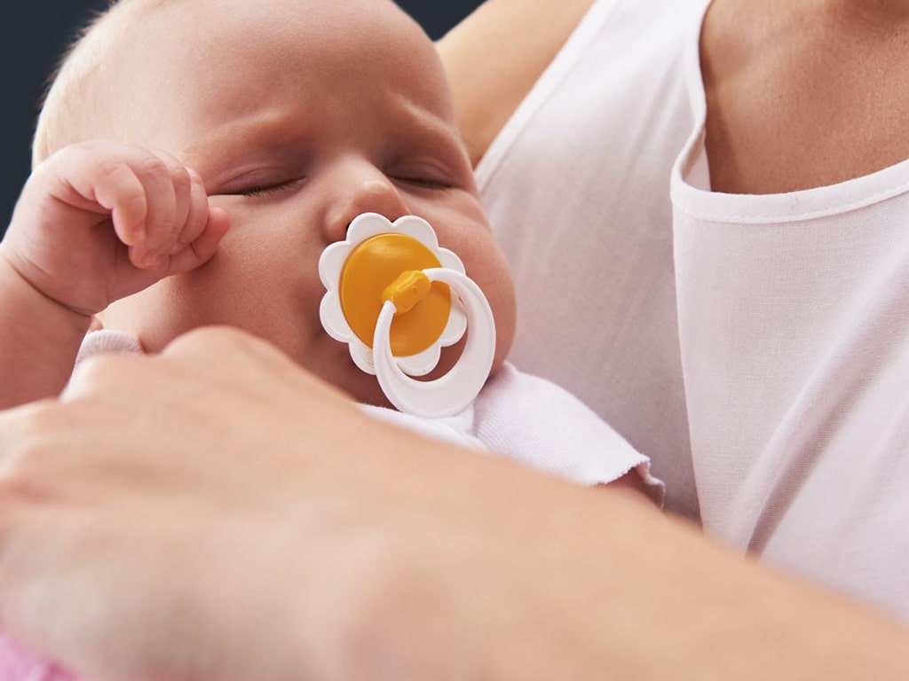 Baby sucking on a pacifier